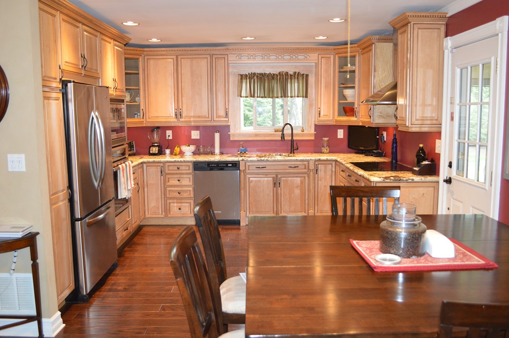 215 Hudson Road Sudbury, MA 01776 - Photo 6 of 18 a kitchen with stainless steel appliances granite countertop a refrigerator a stove top oven a sink dishwasher and wooden cabinets with wooden floor