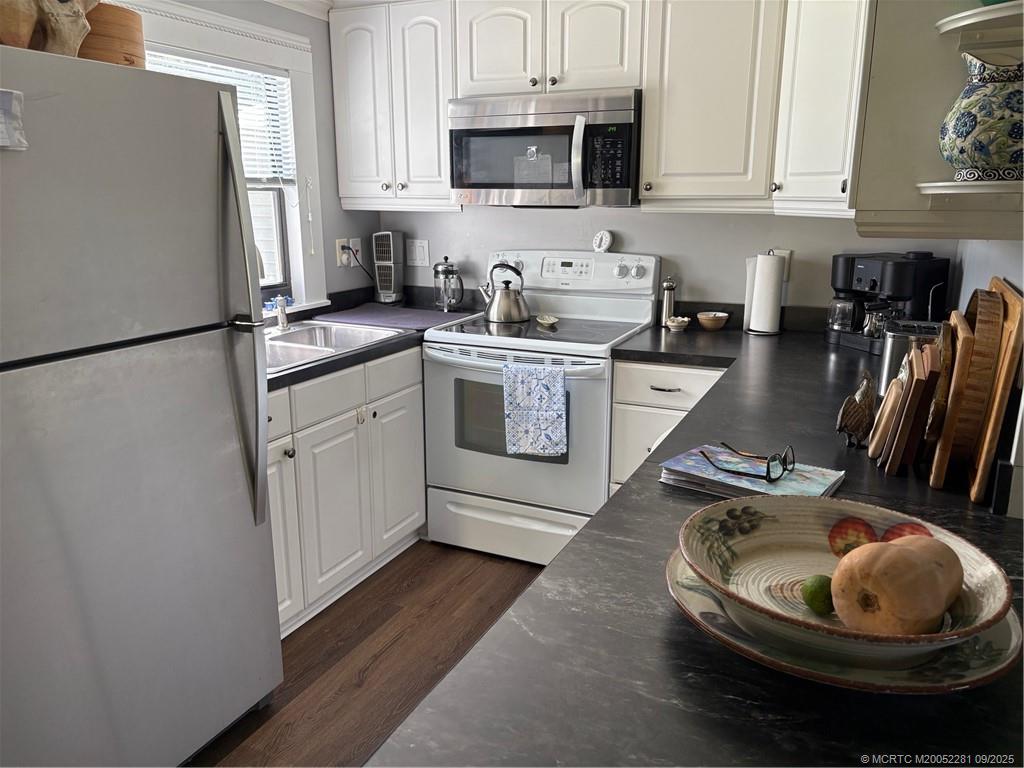 2686 Southwest Monarch Trail Stuart, FL 34997 - Photo 10 of 15 a kitchen with stainless steel appliances kitchen island granite countertop a refrigerator a stove a sink a microwave and cabinets