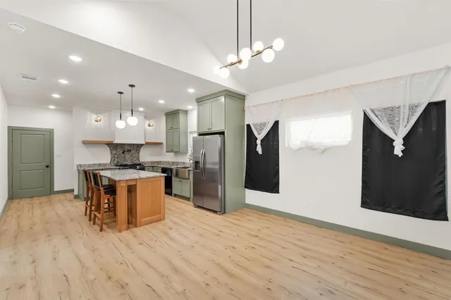 a kitchen with stainless steel appliances kitchen island a refrigerator and a sink