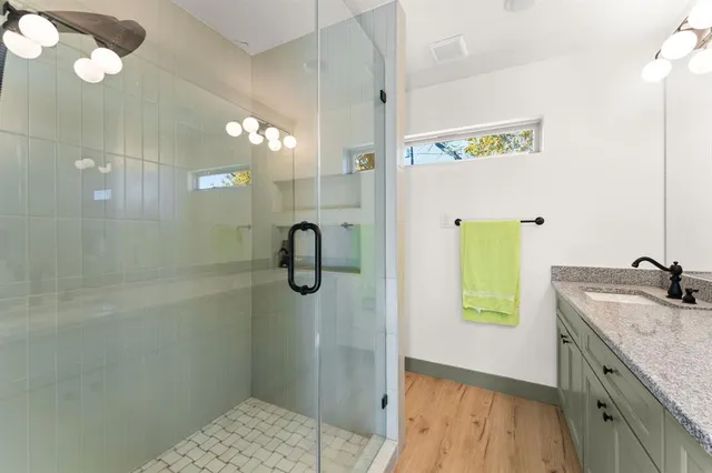 a bathroom with a granite countertop sink and a mirror