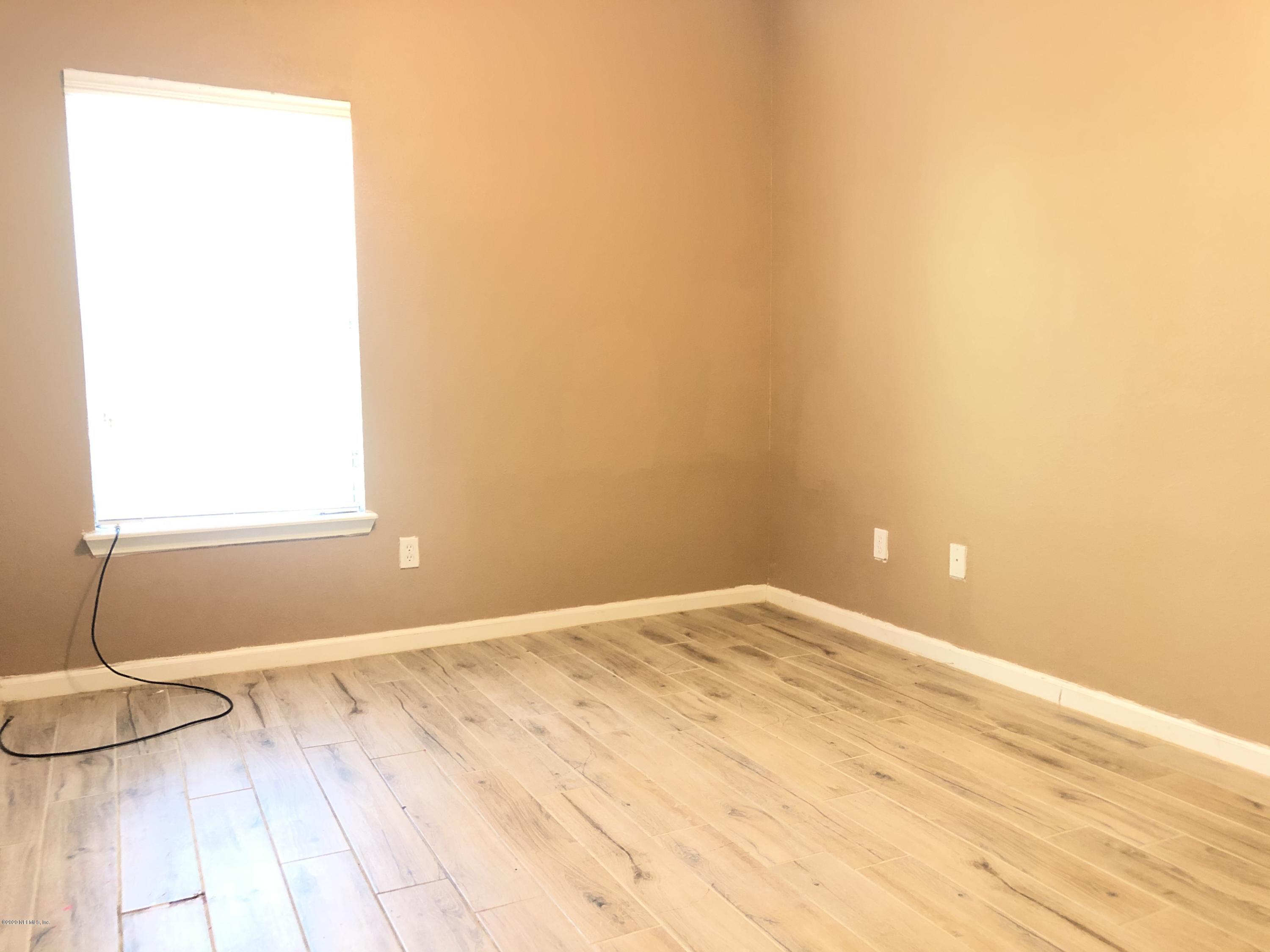 a view of a room with a wooden floor and a window
