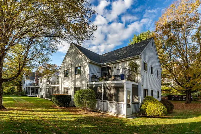 a front view of a house with a garden and trees