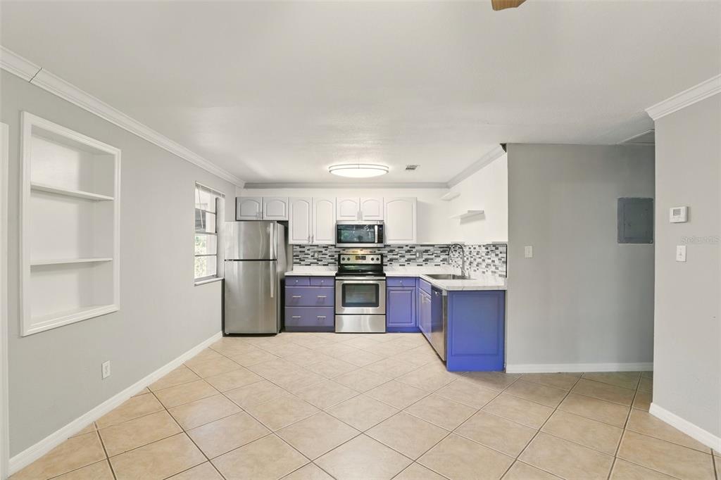 1617 Acacia Road Apopka, FL 32712 - Photo 12 of 30 a kitchen with stainless steel appliances granite countertop a refrigerator and a stove top oven