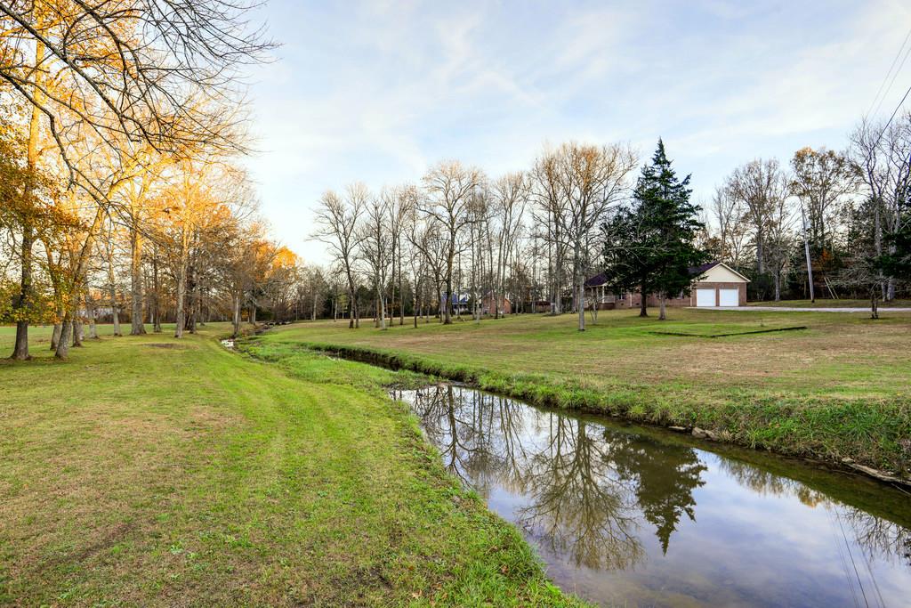 5056 Joe Peay Road Spring Hill, TN 37174 - Photo 4 of 30 a view of a lake with a yard and large trees