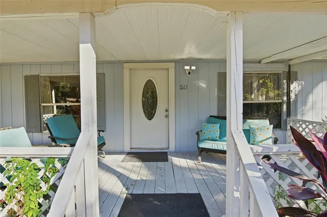 a living room with furniture a flat screen tv and a floor to ceiling window