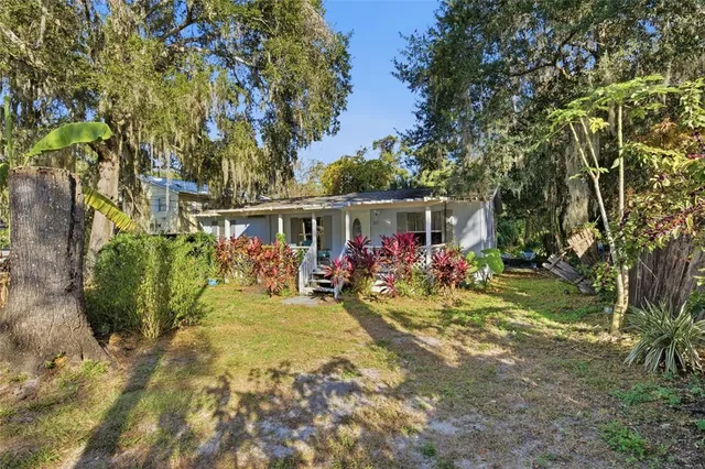 a view of a house with a yard and potted plants