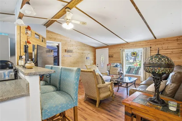 a kitchen with stainless steel appliances granite countertop a dining table chairs and a microwave