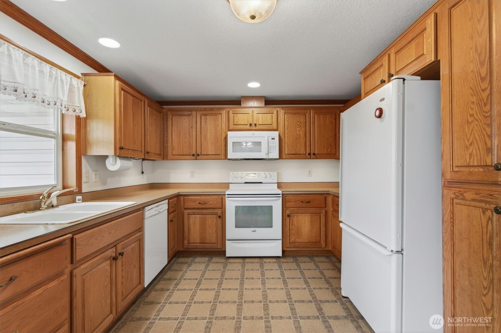 218 West Sunny Sands Road Cathlamet, WA 98612 - Photo 13 of 40 a kitchen with a refrigerator a stove top oven and cabinets