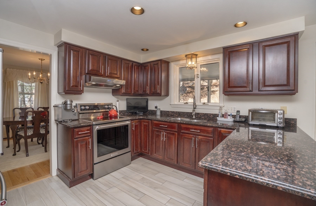 22 Elizabeth Street Amesbury, MA 01913 - Photo 2 of 38 a kitchen with stainless steel appliances granite countertop wooden cabinets a stove top oven a sink and dishwasher