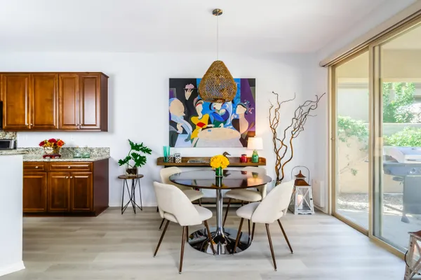 a view of a dining room with furniture a chandelier and wooden floor
