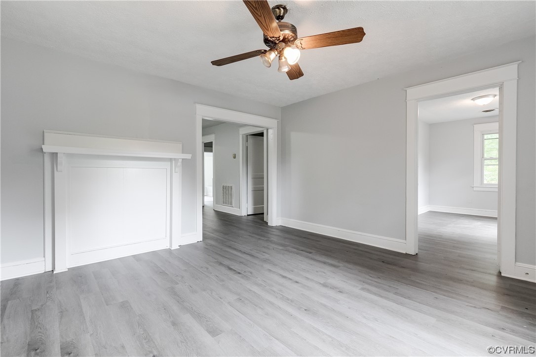 16020 Harrowgate Road Chester, VA 23831 - Photo 3 of 23 an empty room with wooden floor chandelier fan and windows