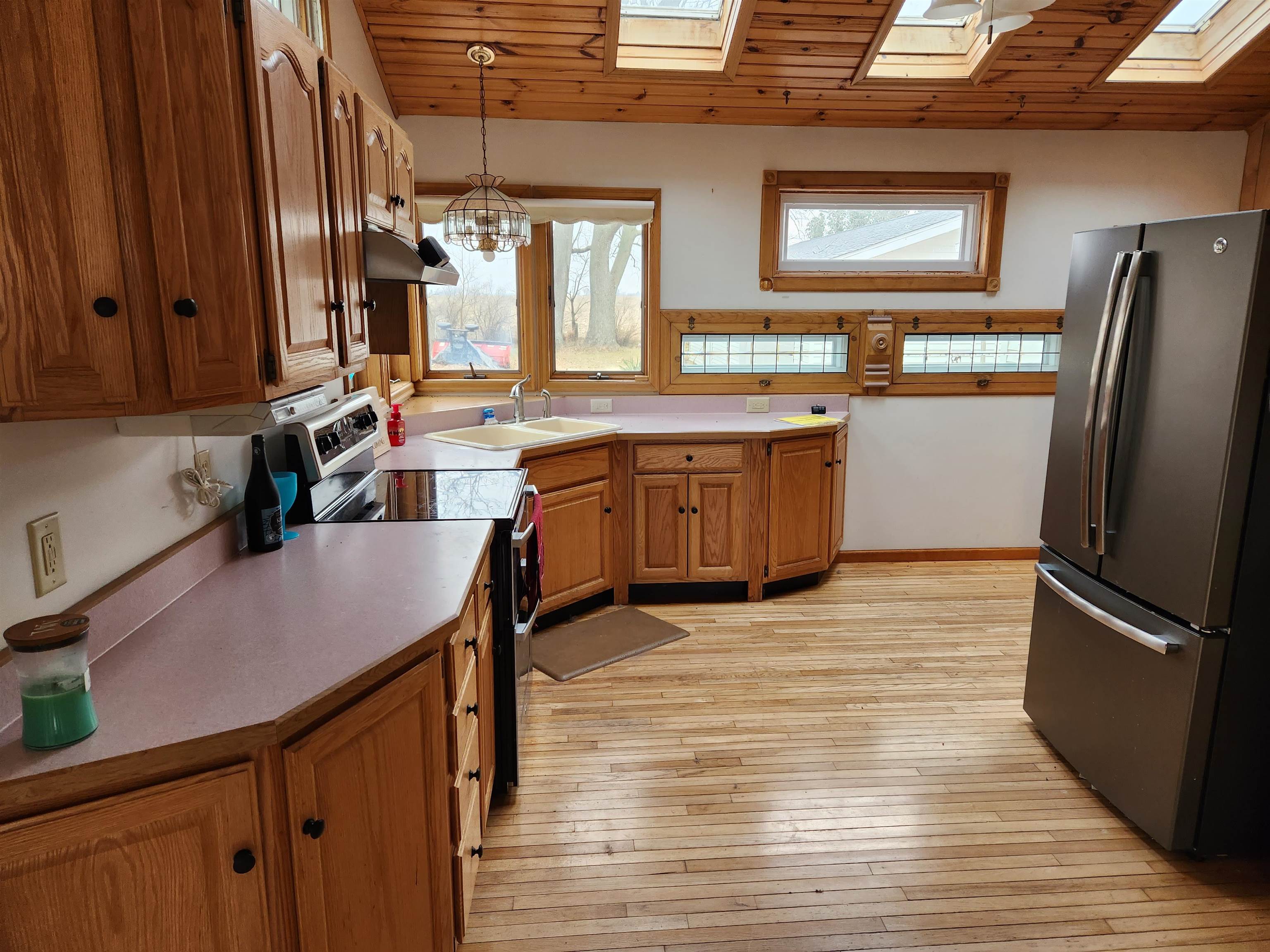 7082 South Hoosier Road Ashton, IL 61006 - Photo 6 of 48 a kitchen with stainless steel appliances granite countertop a refrigerator a sink dishwasher a stove and white countertops with wooden floor