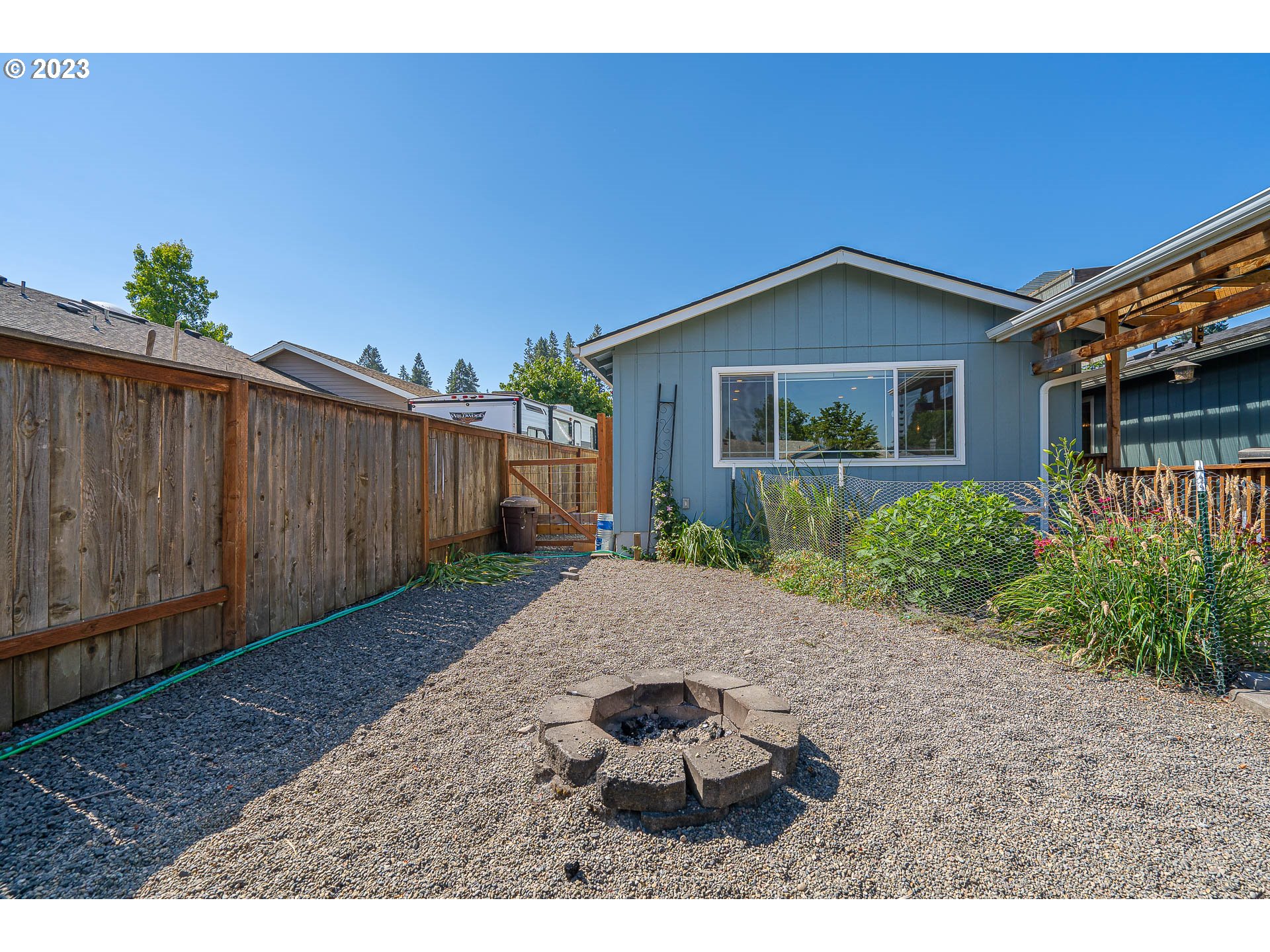 5040 Forsythia Street Springfield, OR 97478 - Photo 31 of 47 a backyard of a house with plants and wooden fence