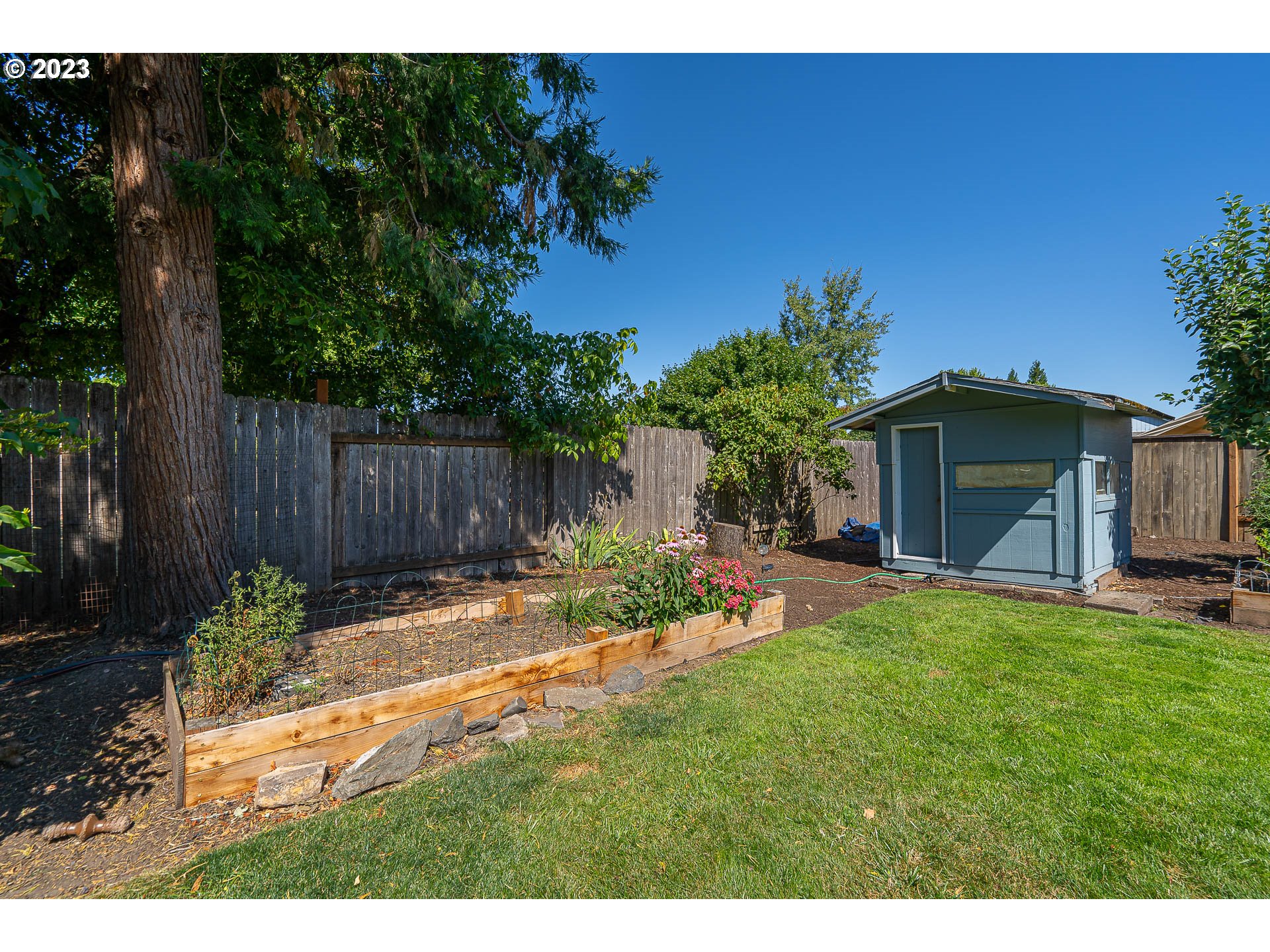 5040 Forsythia Street Springfield, OR 97478 - Photo 40 of 47 a view of a backyard with table and chairs and wooden fence