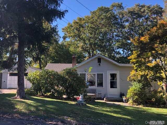 a front view of a house with a yard and trees