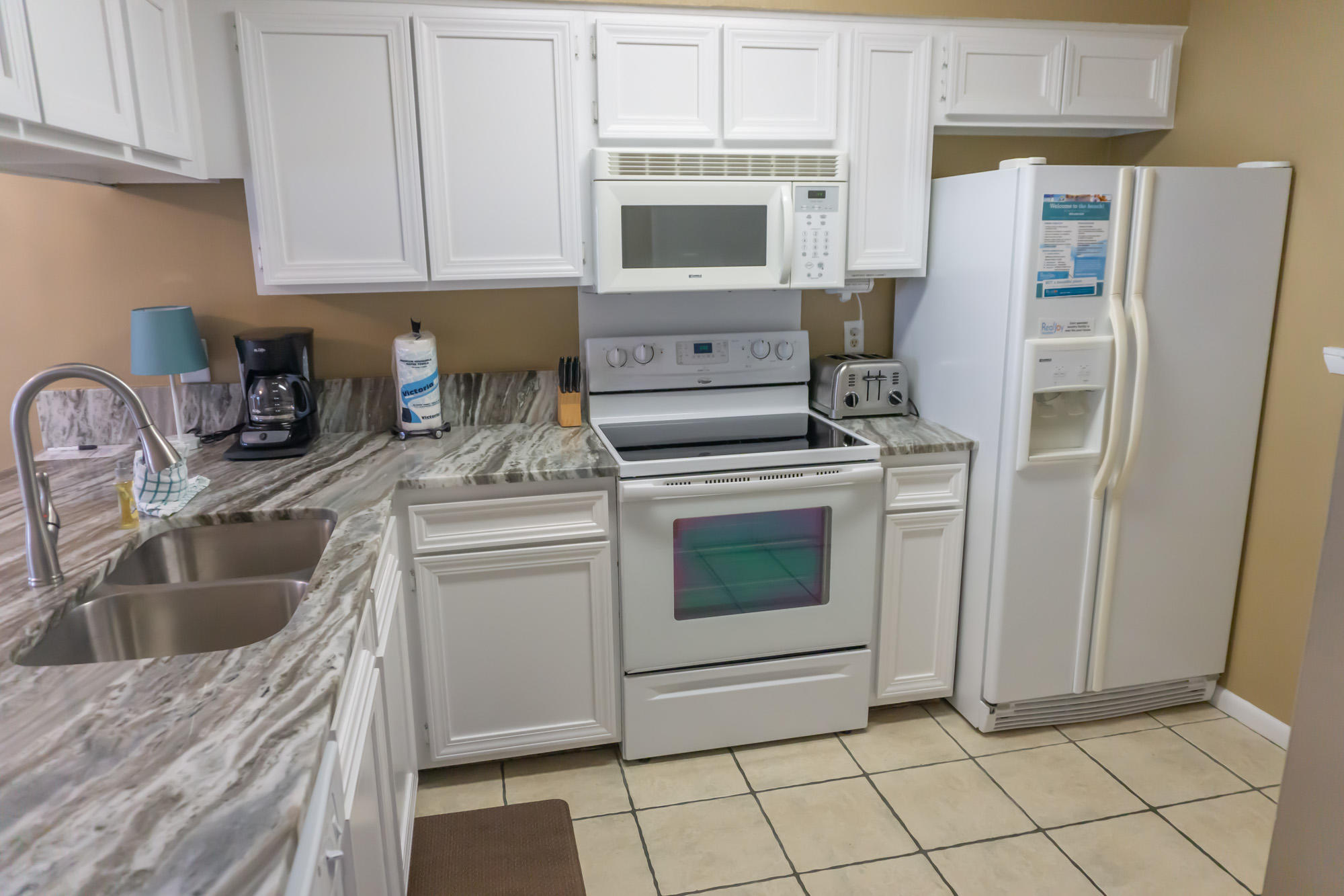 2000 Scenic Gulf Drive, Unit 5 Miramar Beach, FL 32550 - Photo 8 of 54 a kitchen with granite countertop a sink stove and refrigerator