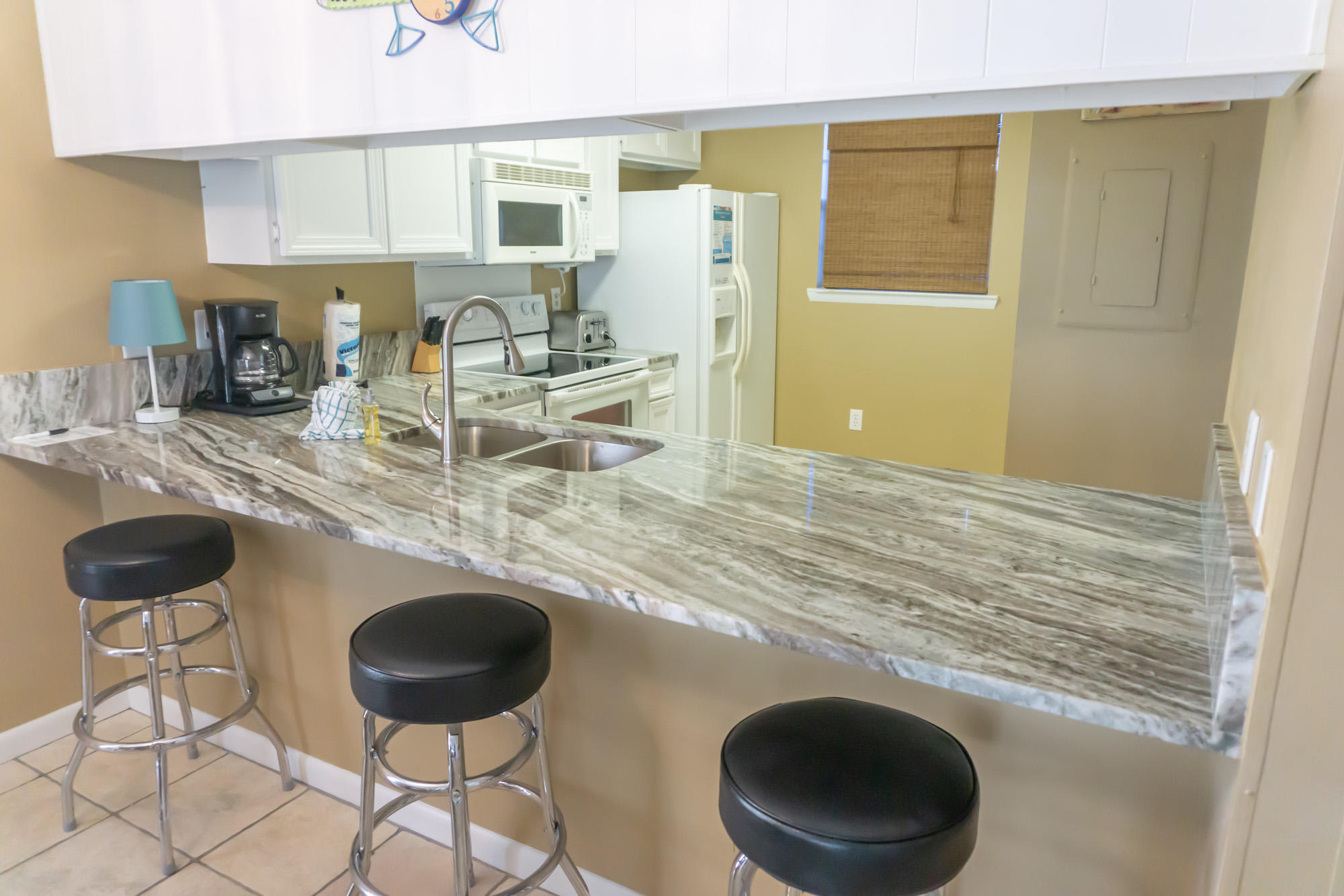 2000 Scenic Gulf Drive, Unit 5 Miramar Beach, FL 32550 - Photo 9 of 54 a kitchen with granite countertop a sink a stove and a refrigerator