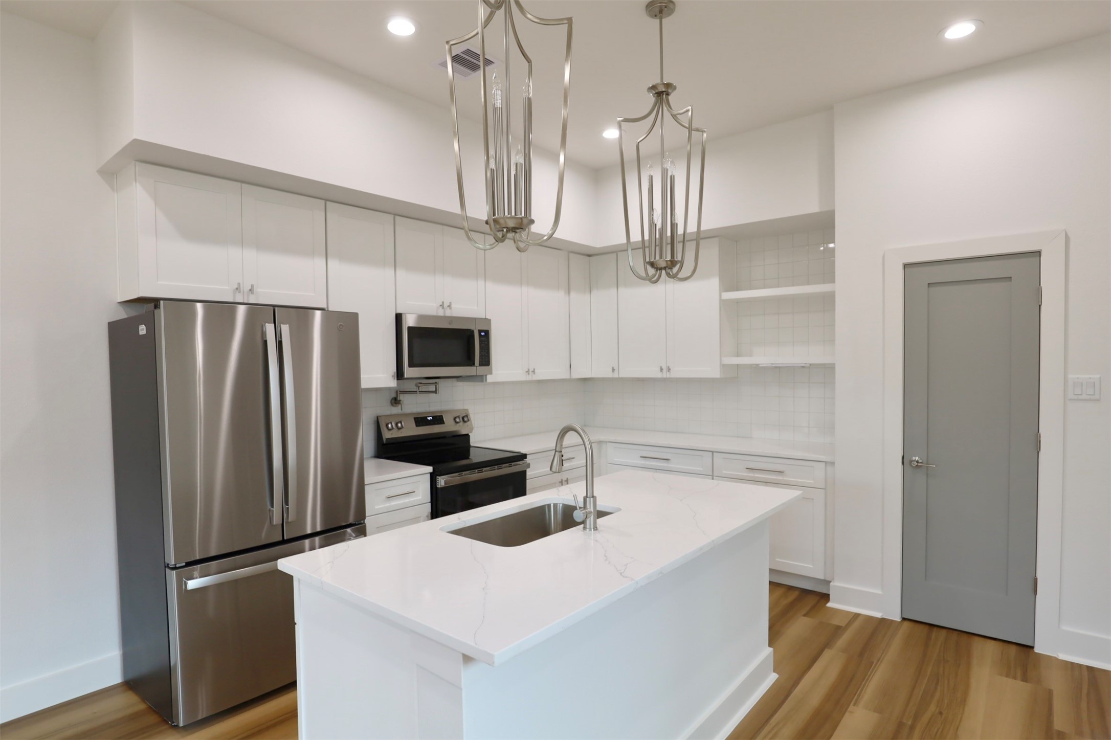 421 East 41st Street Houston, TX 77022 - Photo 11 of 32 a kitchen with stainless steel appliances a refrigerator sink and wooden floor