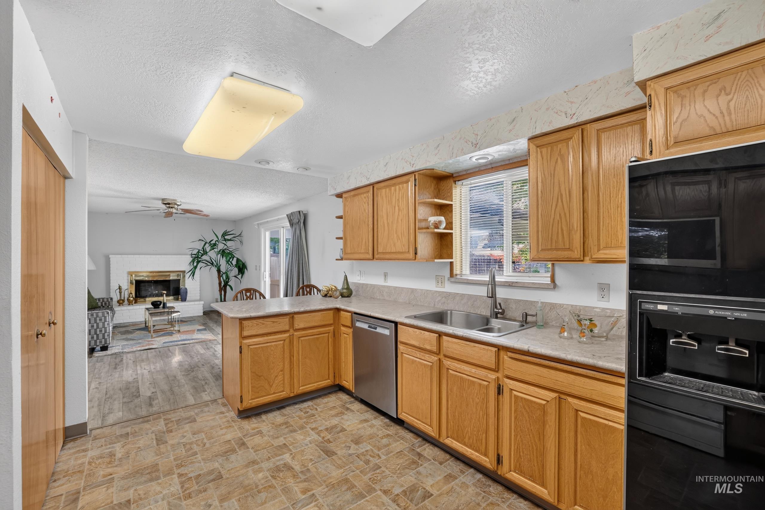 9055 West Highlander Road Boise, ID 83709 - Photo 11 of 39 Kitchen featuring wood cabinetry, a double basin stainless steel sink, and light-toned countertops