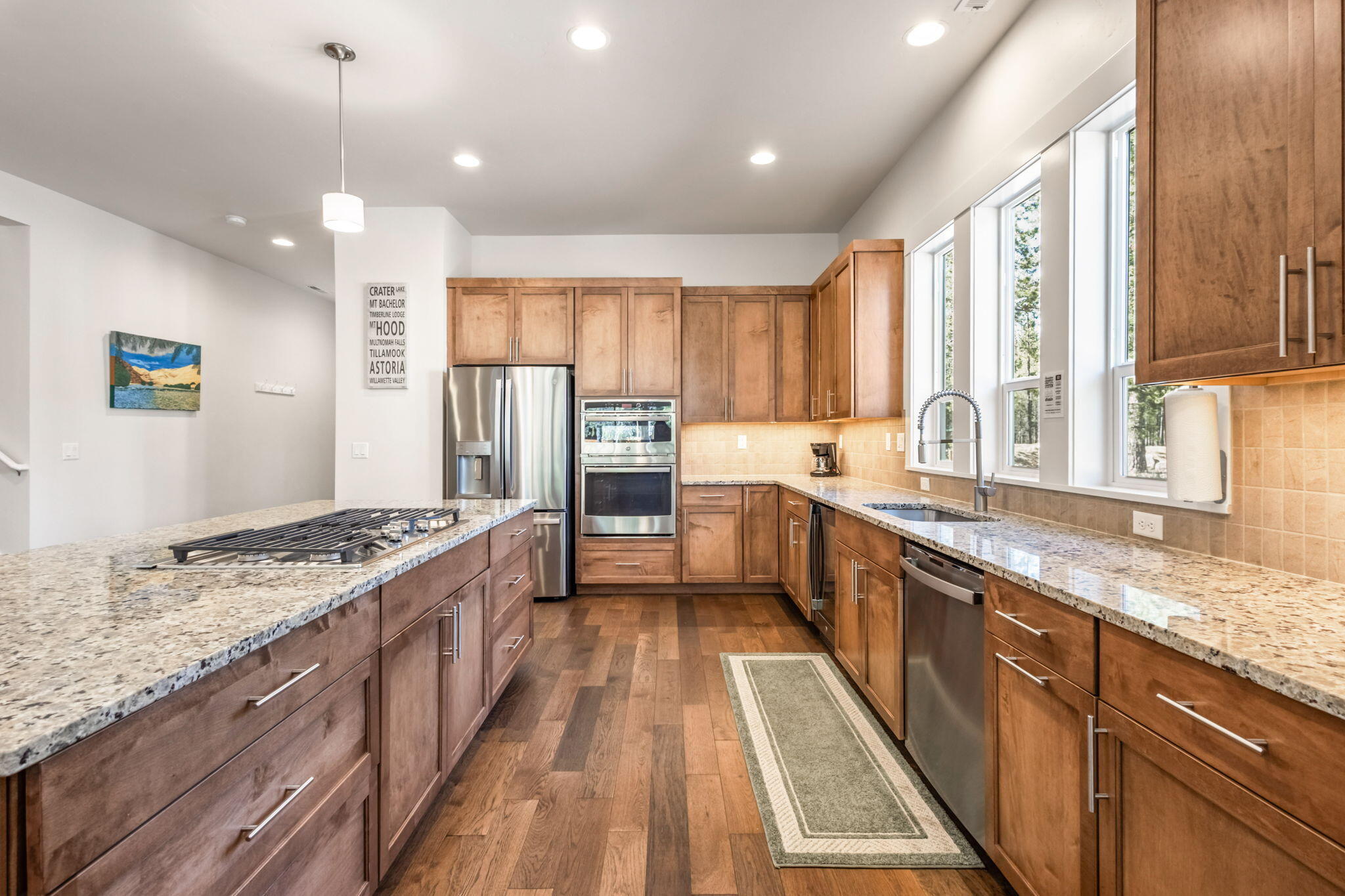 17138 Downey Road Bend, OR 97707 - Photo 4 of 57 Chef's kitchen features granite countertops, a kitchen island, pantry, and upgraded appliances, including a wine refrigerator.