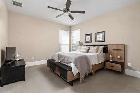 a bedroom with a bed and a ceiling fan