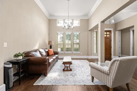 a living room with furniture and a chandelier