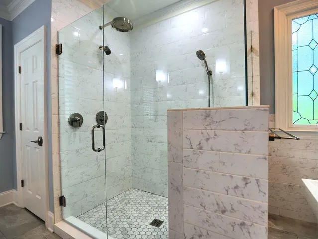 a bedroom with a bed a chandelier and a window