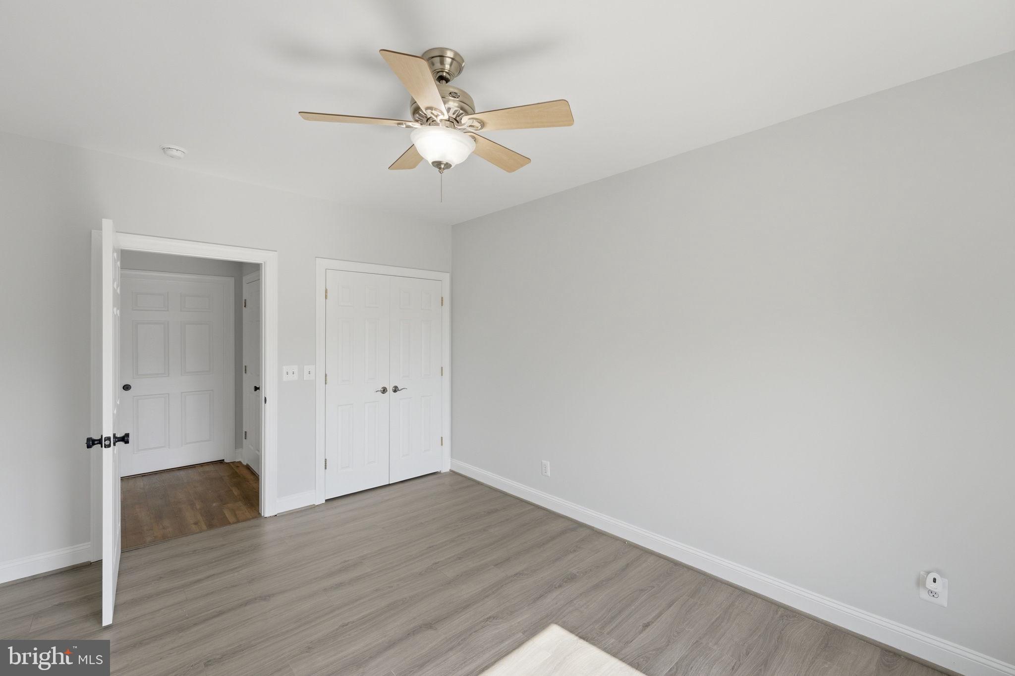 7522 Stubbs Bridge Road Spotsylvania, VA 22551 - Photo 32 of 60 an empty room with wooden floor and ceiling fan