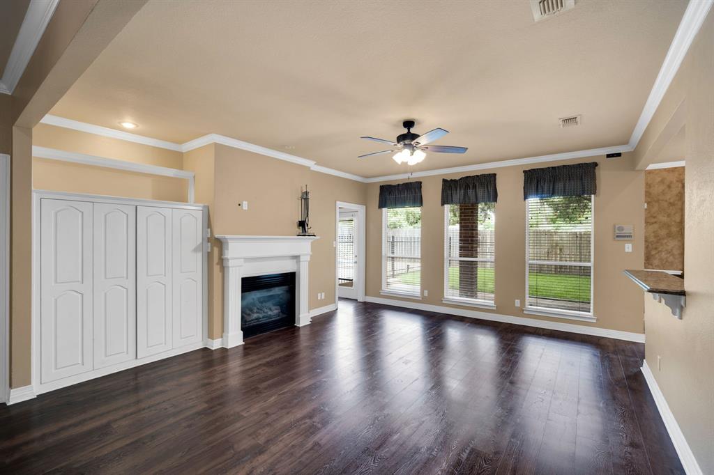 1907 Timber Ridge Court Cedar Hill, TX 75104 - Photo 9 of 30 Living area featuring wood-finish flooring, a white mantel fireplace, and built-in white cabinetry