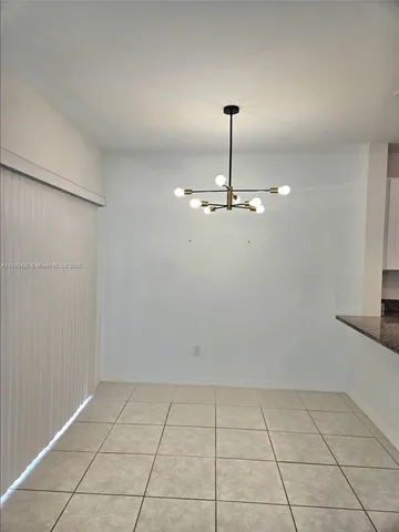 a view of empty room with a kitchen
