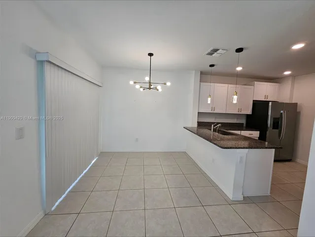 a large kitchen with granite countertop a stove a sink and a refrigerator