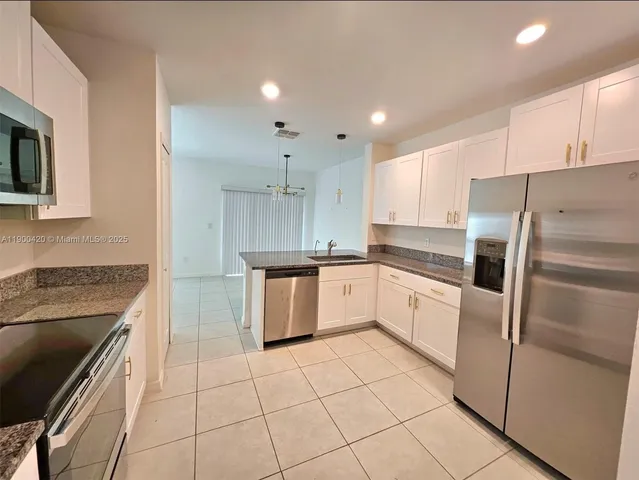 a kitchen with a sink a counter top space stainless steel appliances and cabinets