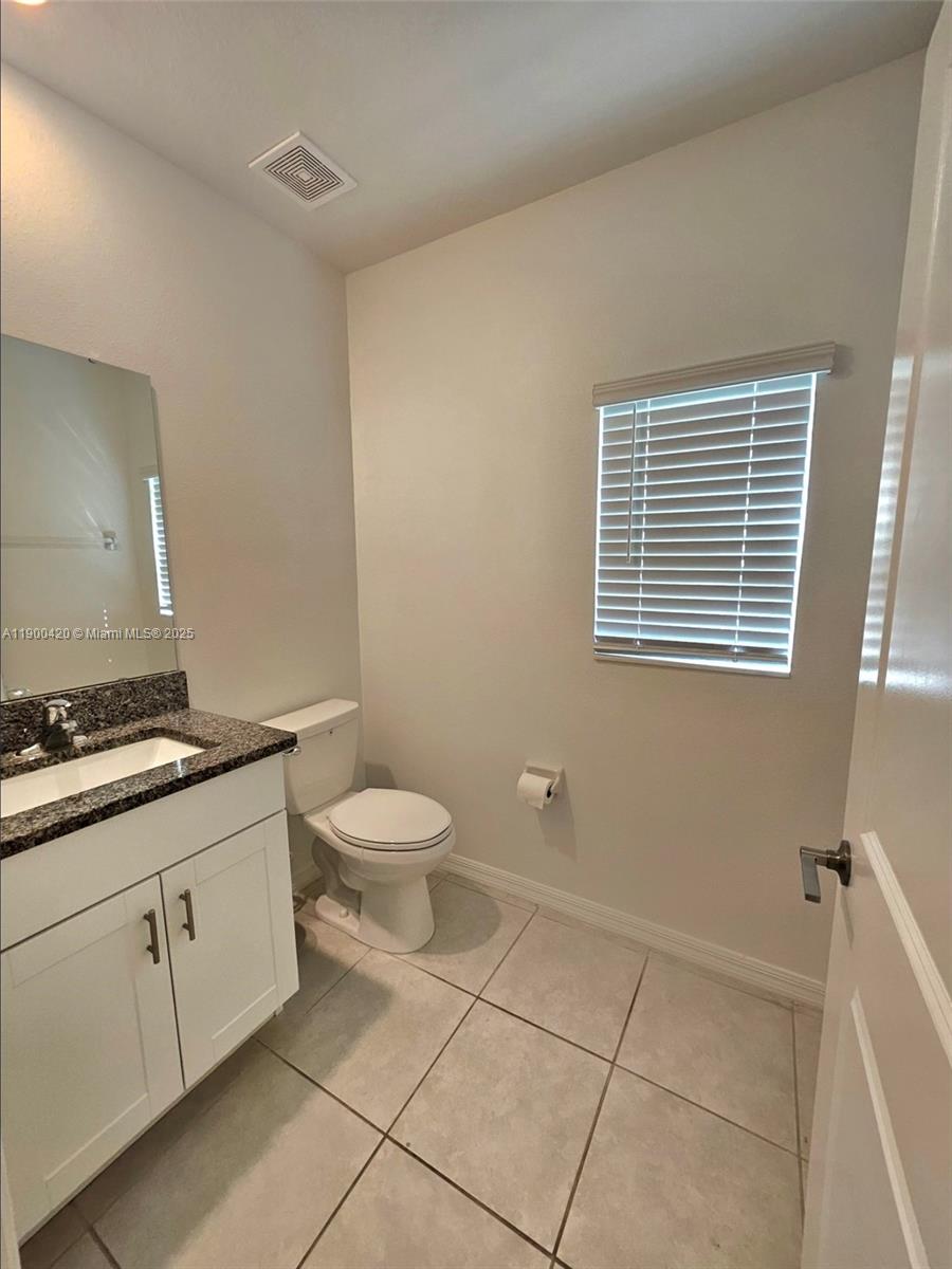 6346 Back Forty Loop Zephyrhills, FL 33541 - Photo 27 of 30 a bathroom with a granite countertop toilet a sink a mirror and a shower