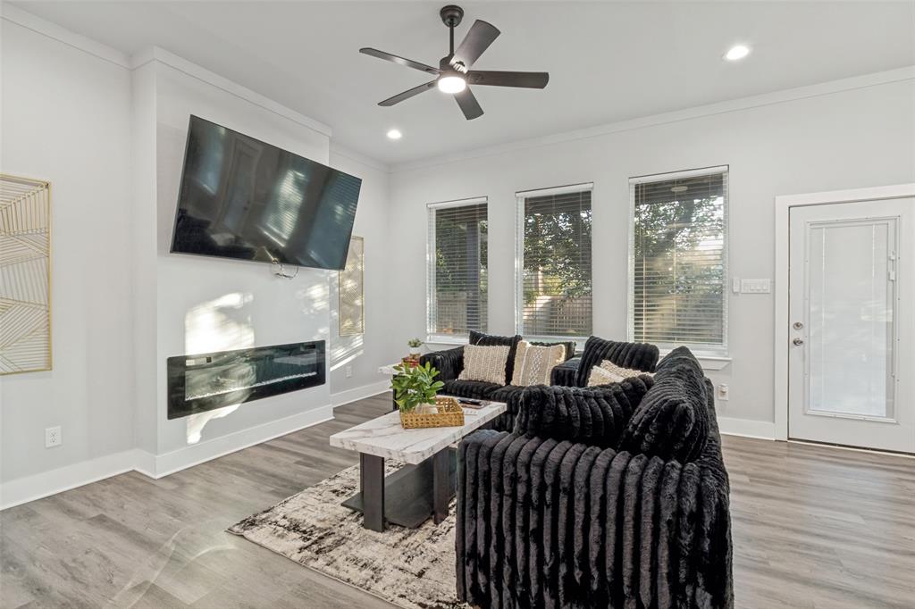 7909 Ivory Lane Dallas, TX 75216 - Photo 8 of 20 a living room with furniture a flat screen tv and a fireplace