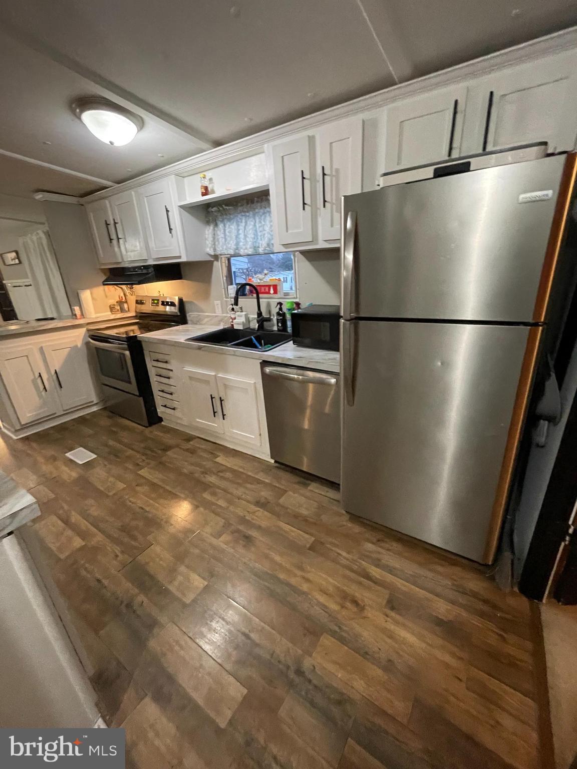 203 Shorewind Road, Unit 203 Bear, DE 19701 - Photo 13 of 20 a kitchen with stainless steel appliances a refrigerator sink and white cabinets