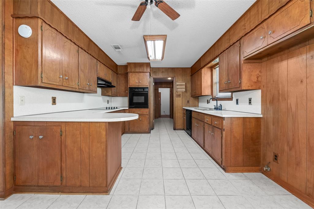3092 North Trinity Street Decatur, TX 76234 - Photo 11 of 29 a kitchen with stainless steel appliances granite countertop a sink counter space cabinets and a window