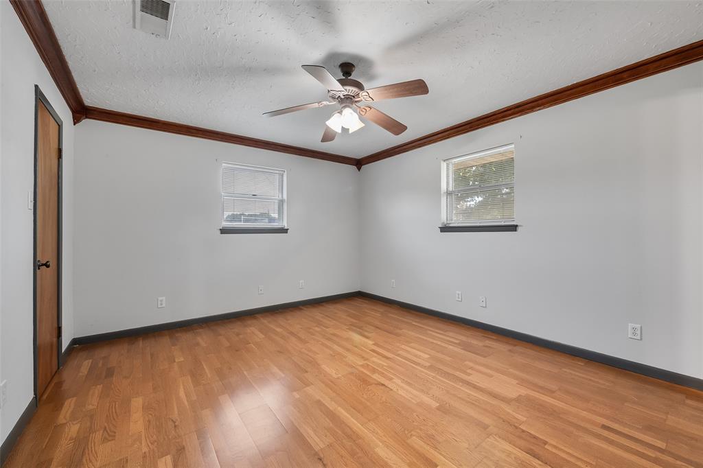 3092 North Trinity Street Decatur, TX 76234 - Photo 16 of 29 an empty room with wooden floor chandelier fan and windows