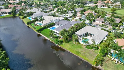 an aerial view of a house with a yard and lake view in back