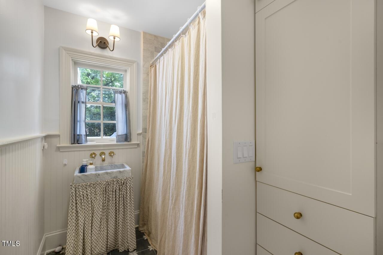 2726 Anderson Drive Raleigh, NC 27608 - Photo 28 of 45 a bathroom with a window and a shower