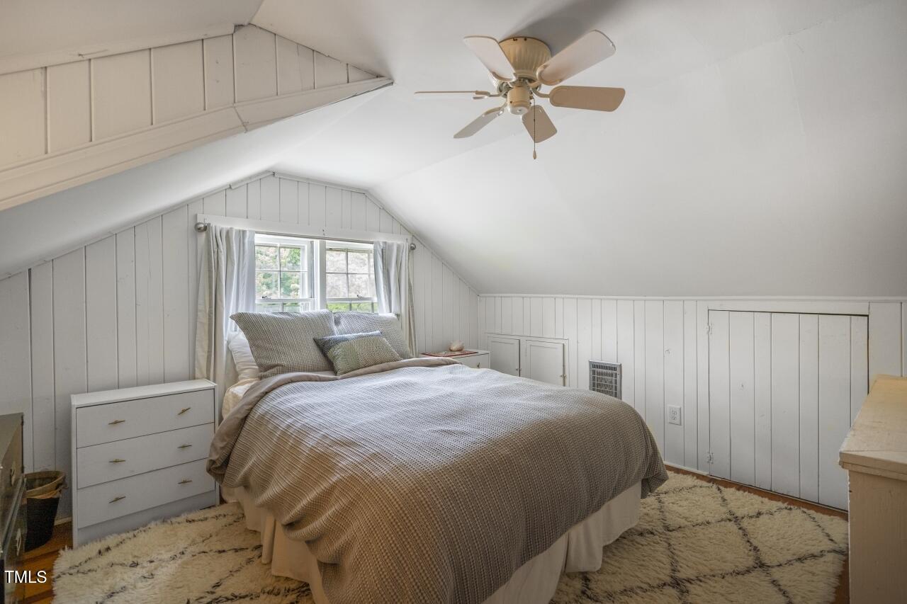 2726 Anderson Drive Raleigh, NC 27608 - Photo 33 of 45 a bedroom with a large bed and a chandelier