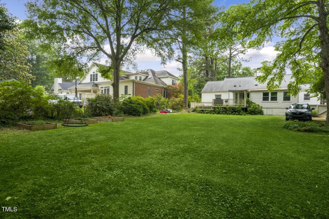 2726 Anderson Drive Raleigh, NC 27608 - Photo 43 of 45 a view of a white house in front of a big yard with large trees