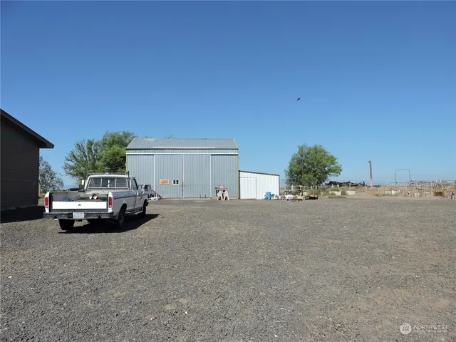 a view of a yard with plants and trees