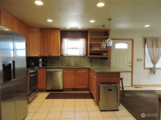 a modern kitchen with stainless steel appliances granite countertop a refrigerator and a sink