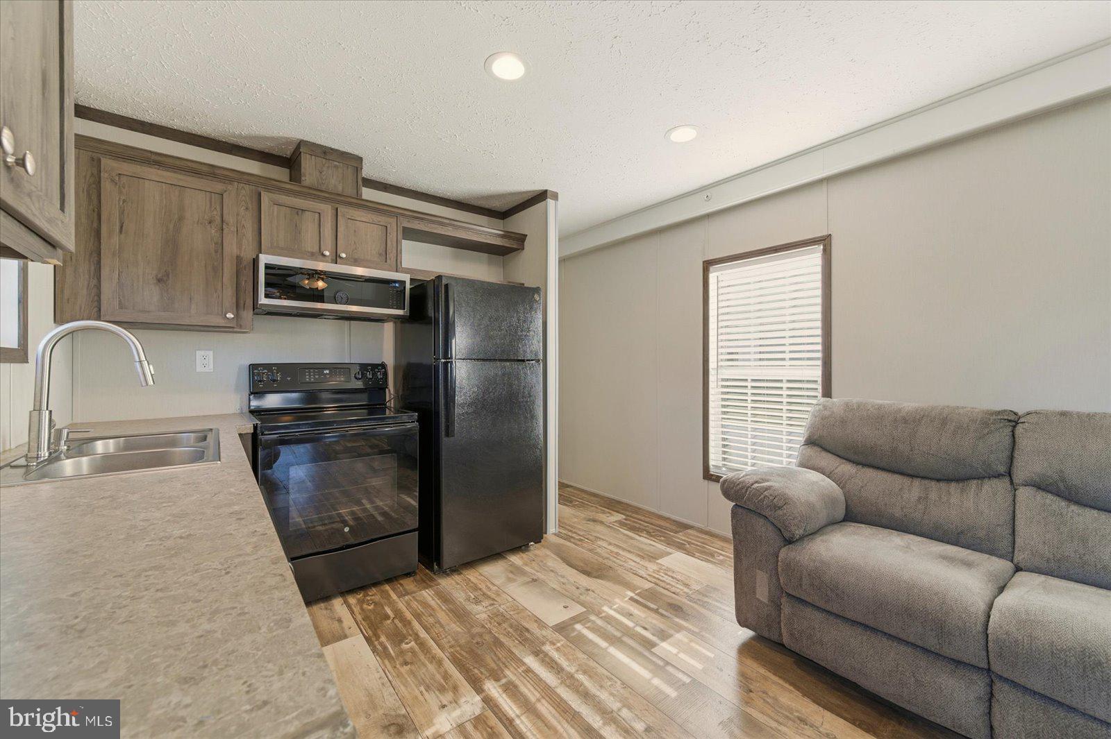 12346 Old Bridge Road, Unit 112 Ocean City, MD 21842 - Photo 13 of 72 a kitchen with stainless steel appliances granite countertop a refrigerator and a sink