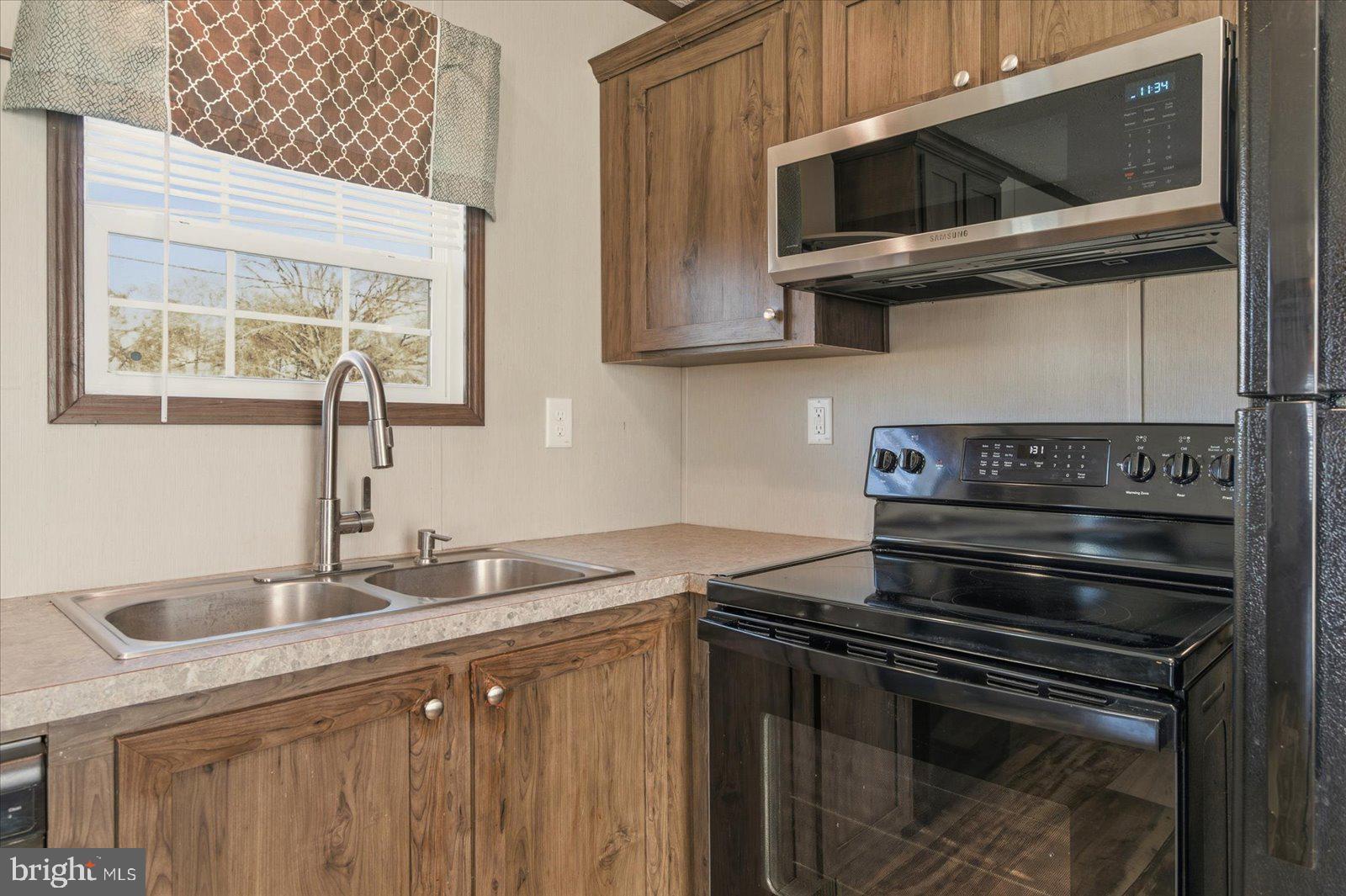 12346 Old Bridge Road, Unit 112 Ocean City, MD 21842 - Photo 17 of 72 a kitchen with stainless steel appliances granite countertop a sink stove and microwave