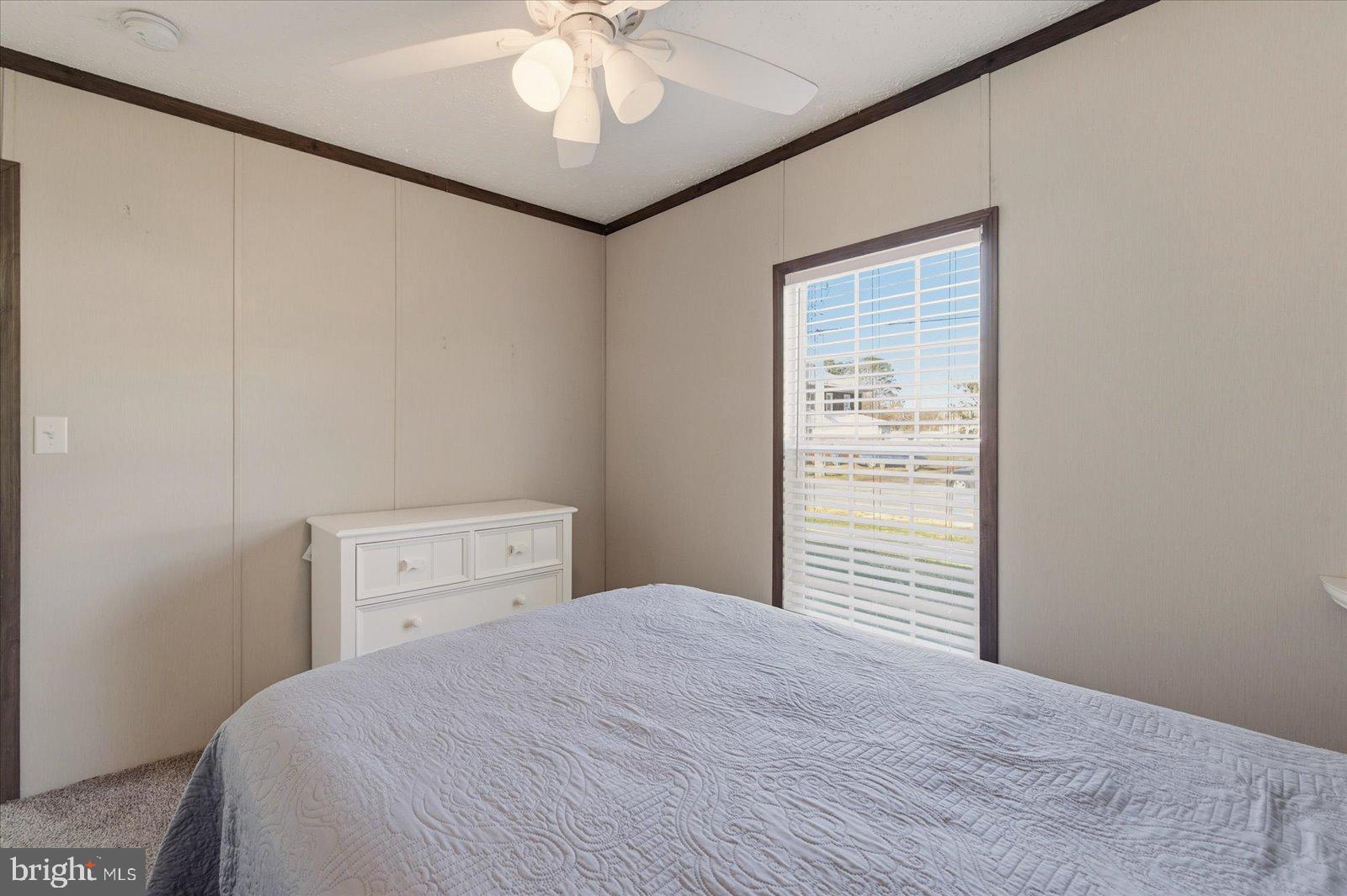 12346 Old Bridge Road, Unit 112 Ocean City, MD 21842 - Photo 26 of 72 a bedroom with a large bed and a chandelier