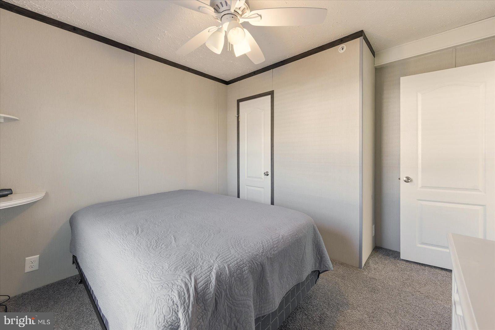 12346 Old Bridge Road, Unit 112 Ocean City, MD 21842 - Photo 27 of 72 a bedroom with a bed and a chandelier