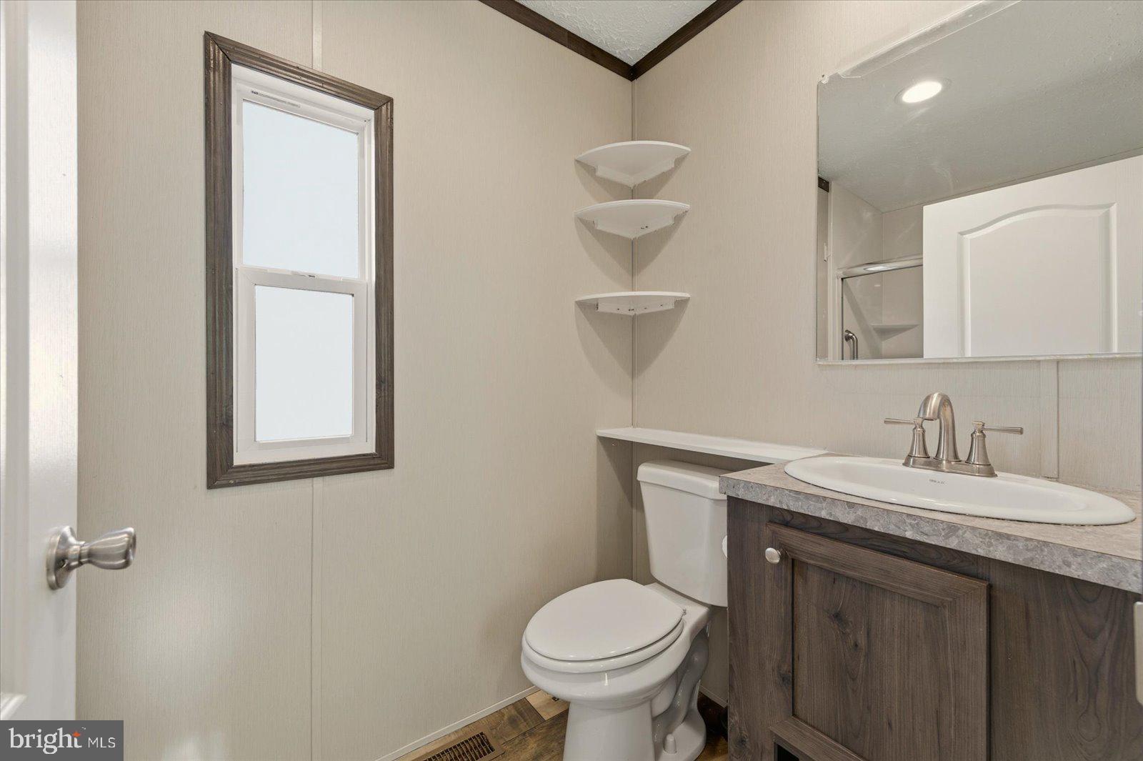 12346 Old Bridge Road, Unit 112 Ocean City, MD 21842 - Photo 30 of 72 a bathroom with a toilet sink and mirror