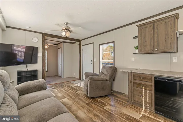 a living room with furniture a flat screen tv and a window