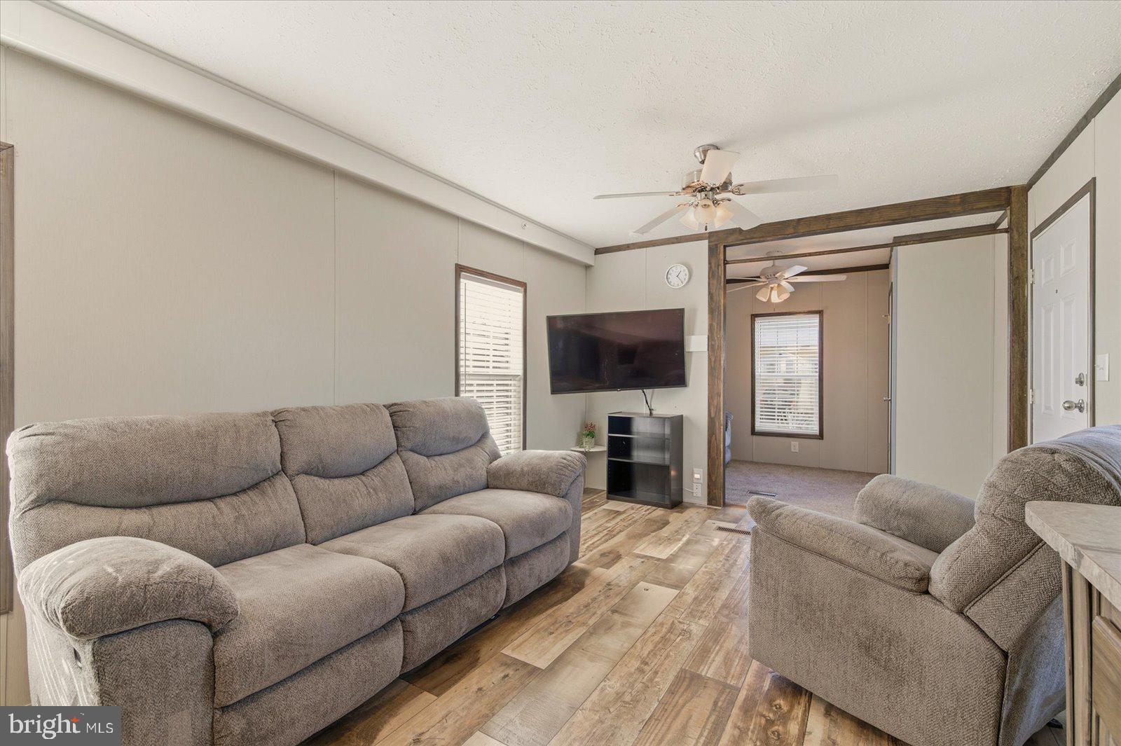 12346 Old Bridge Road, Unit 112 Ocean City, MD 21842 - Photo 10 of 72 a living room with furniture a flat screen tv and a window